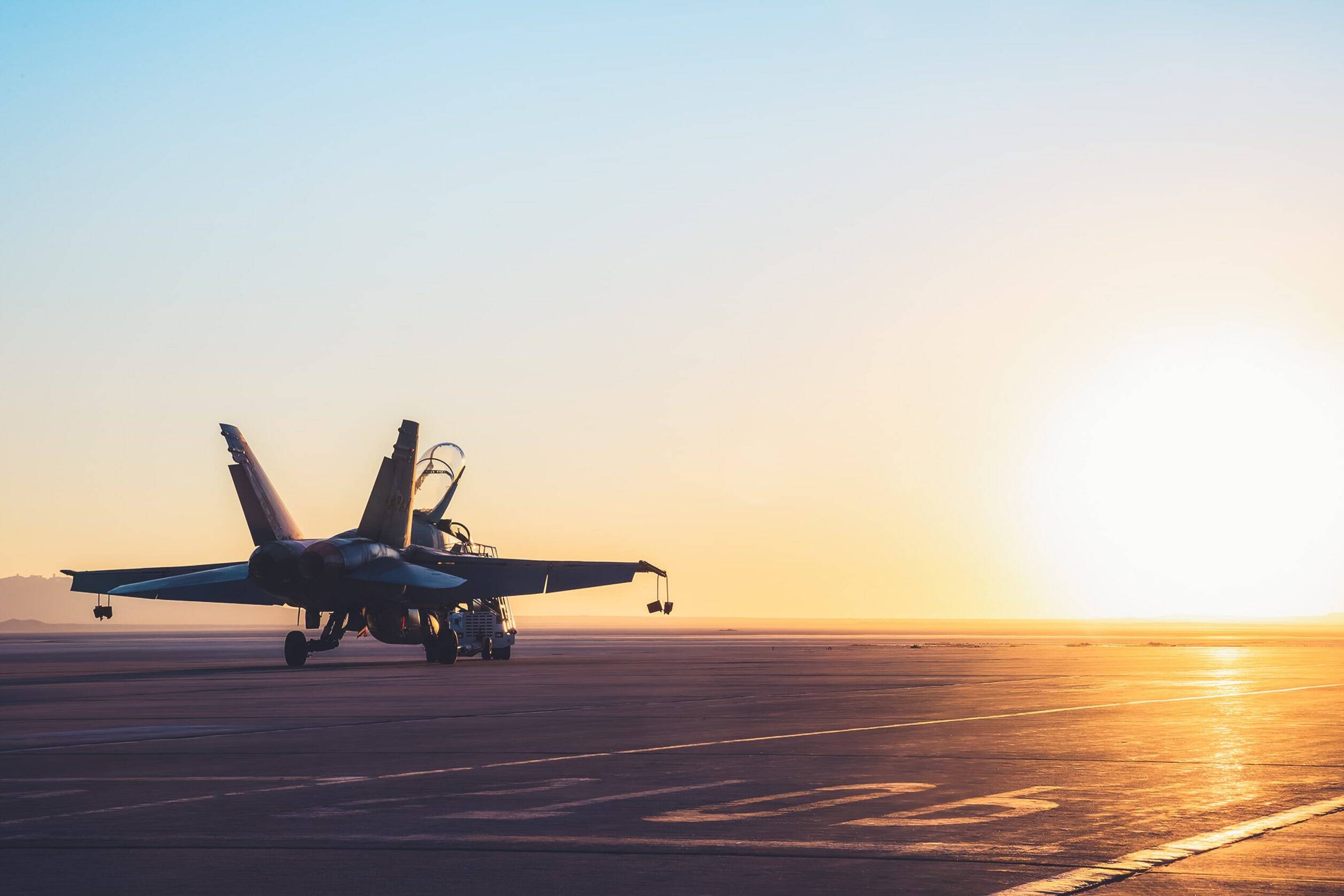 military jet on runway during sunset