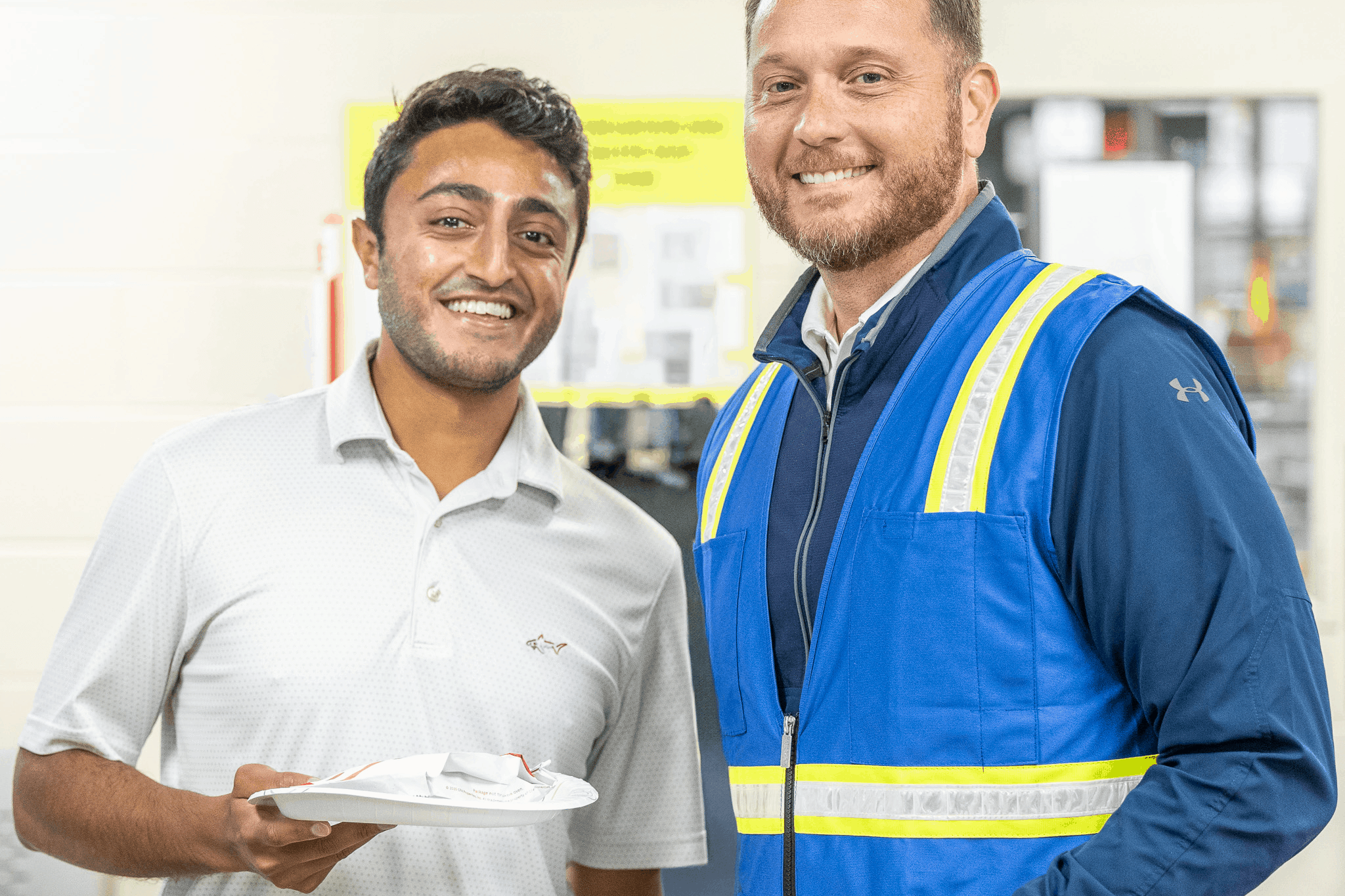 2 employees smiling with food plates